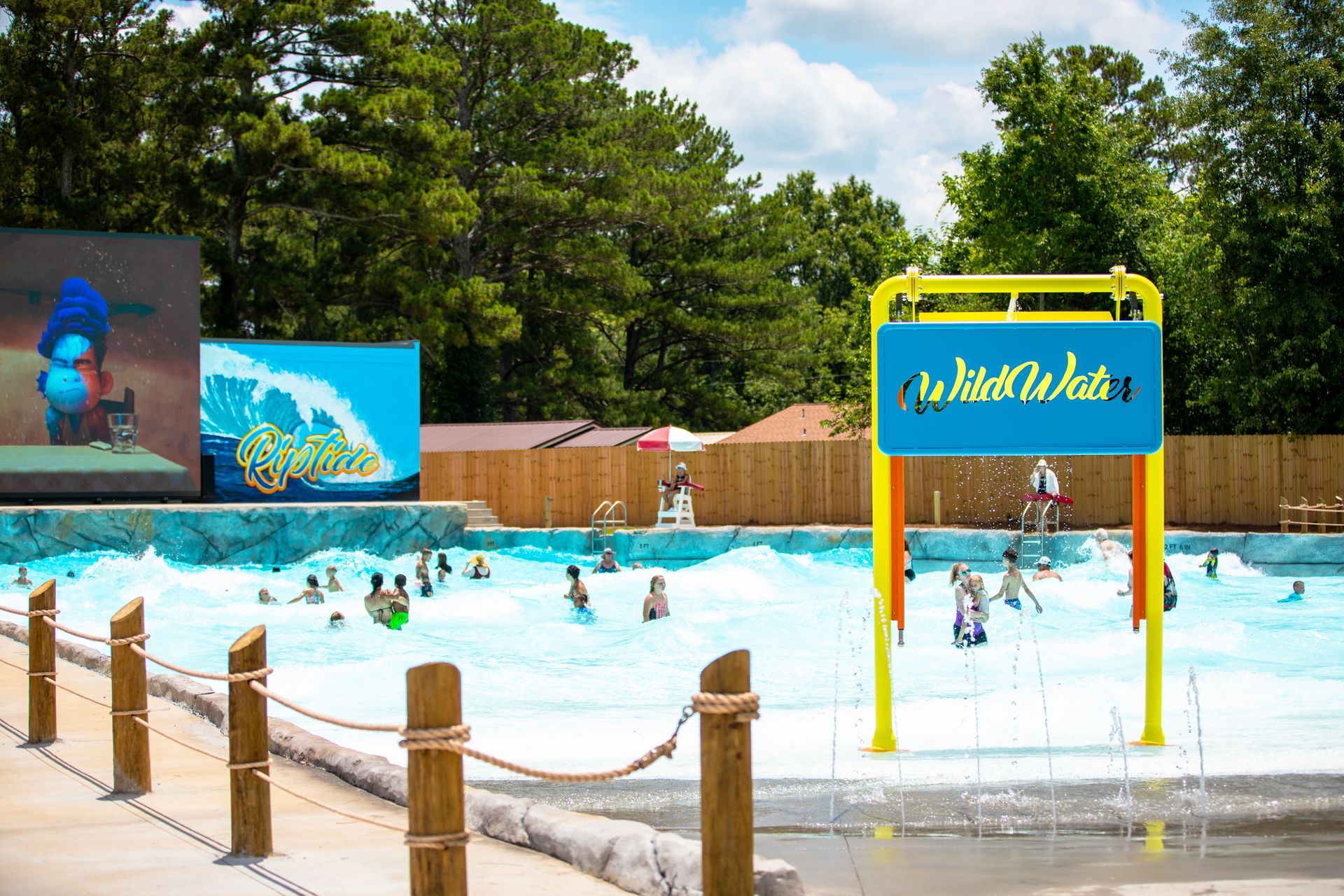 A group of people are swimming in a pool at a water park.