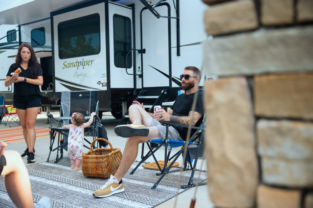 a group of people are sitting in chairs in front of a rv .