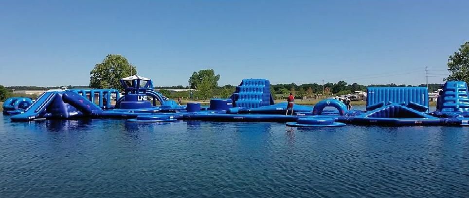 A large inflatable water park is floating on top of a lake.