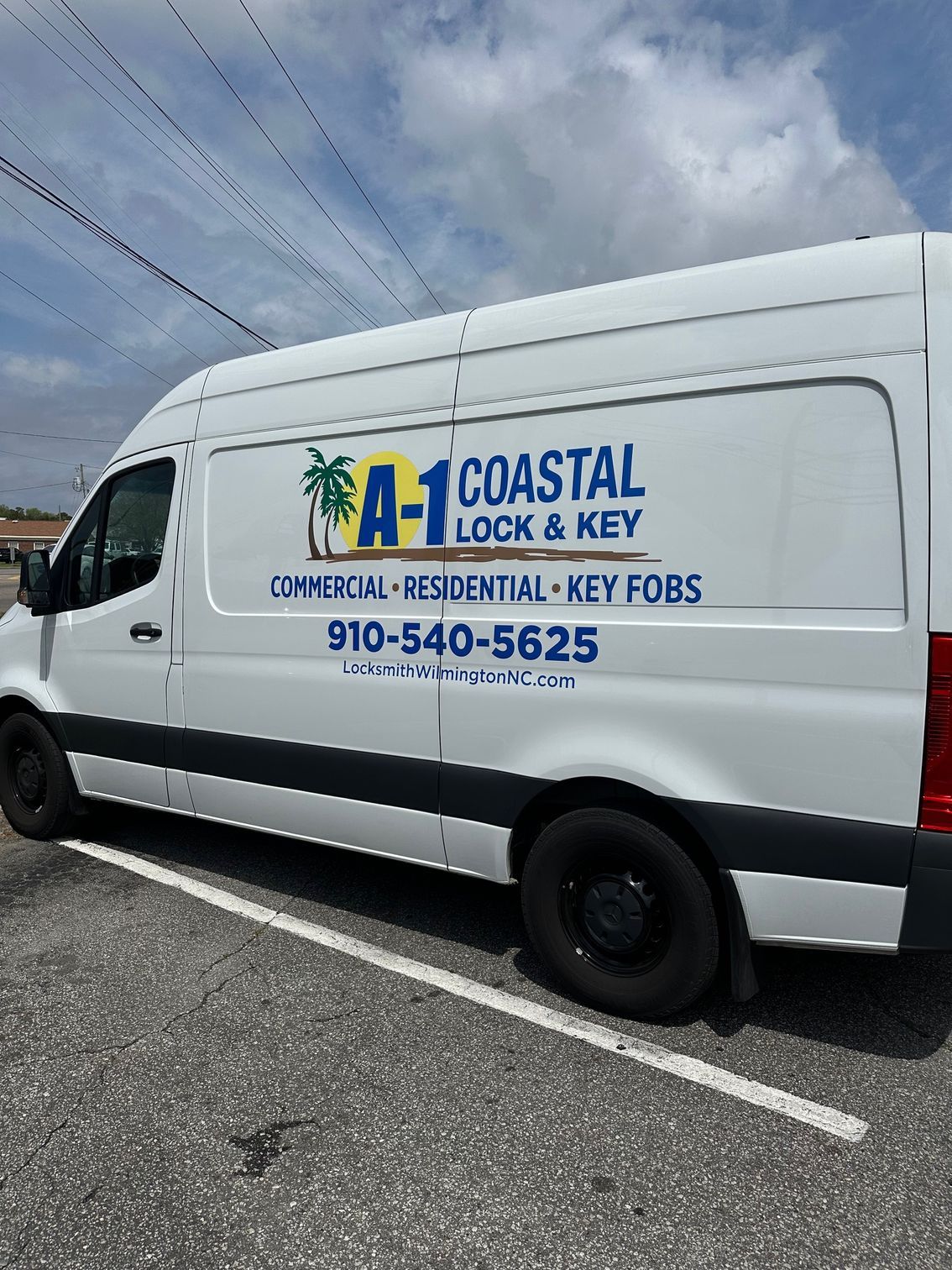 A coastal lock and key van is parked in front of a building