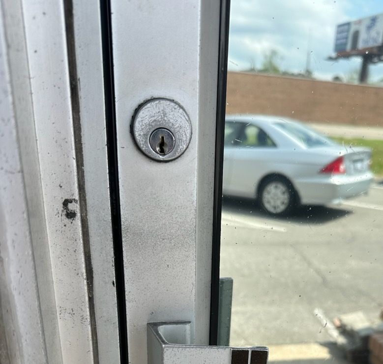 A close up of a door with a car in the background