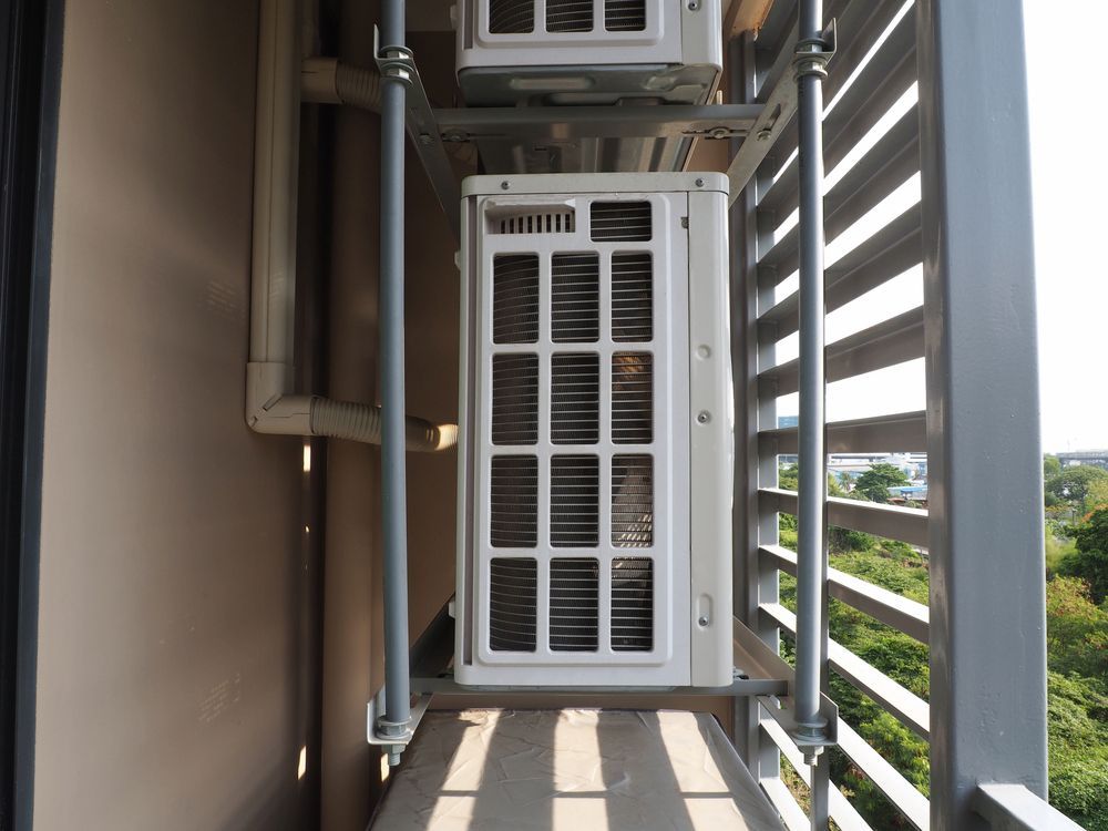 White Air Conditioner Unit on a Metal Platform With a Protective Railing — Climacool Air Conditioning in Palm Cove, QLD