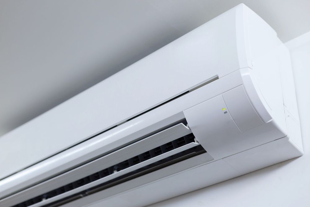 White Wall-mounted Air Conditioner Unit on a Light-colored Wall — Climacool Air Conditioning in Trinity Beach, QLD