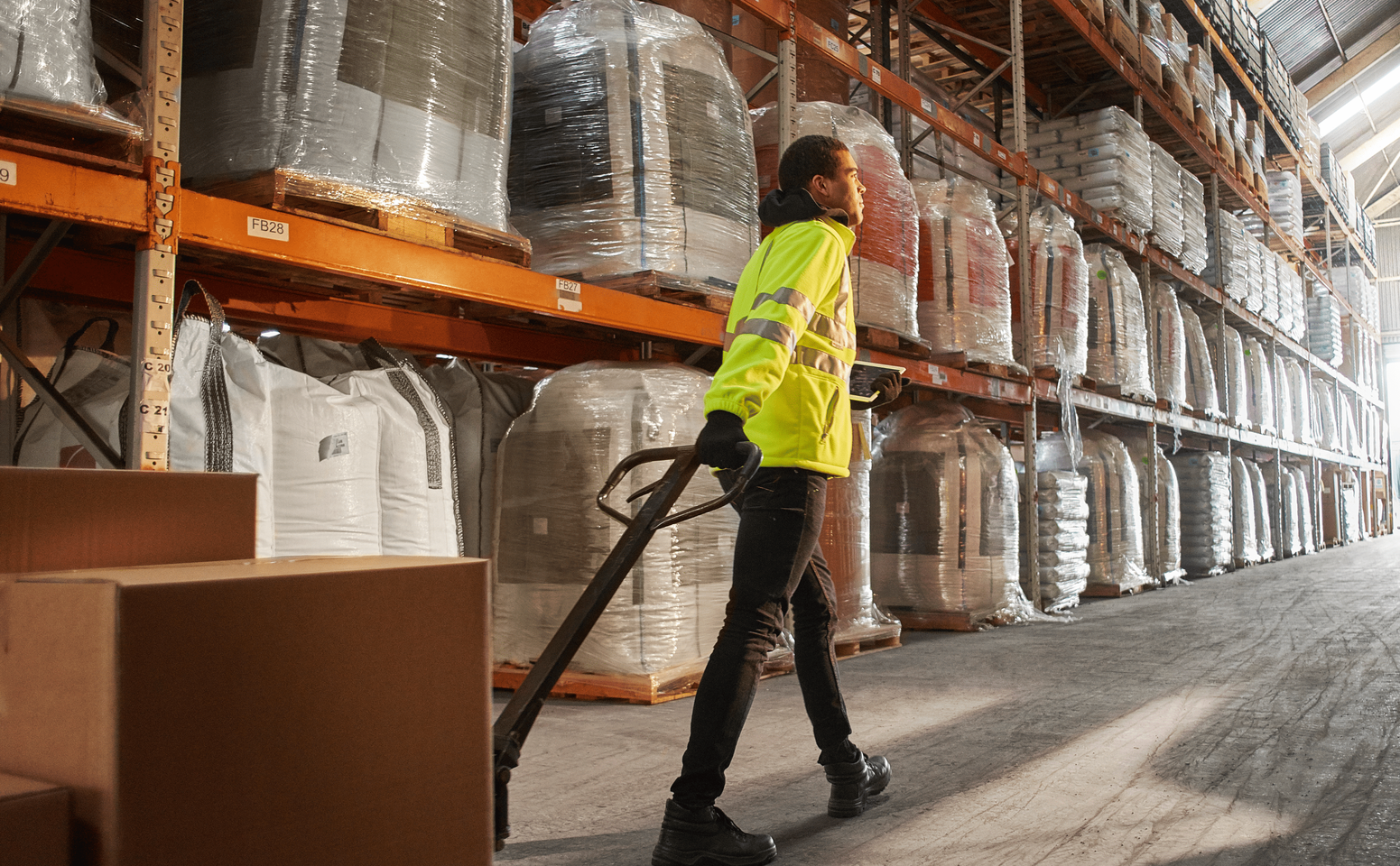 Two men in hi-vis talking in a warehouse