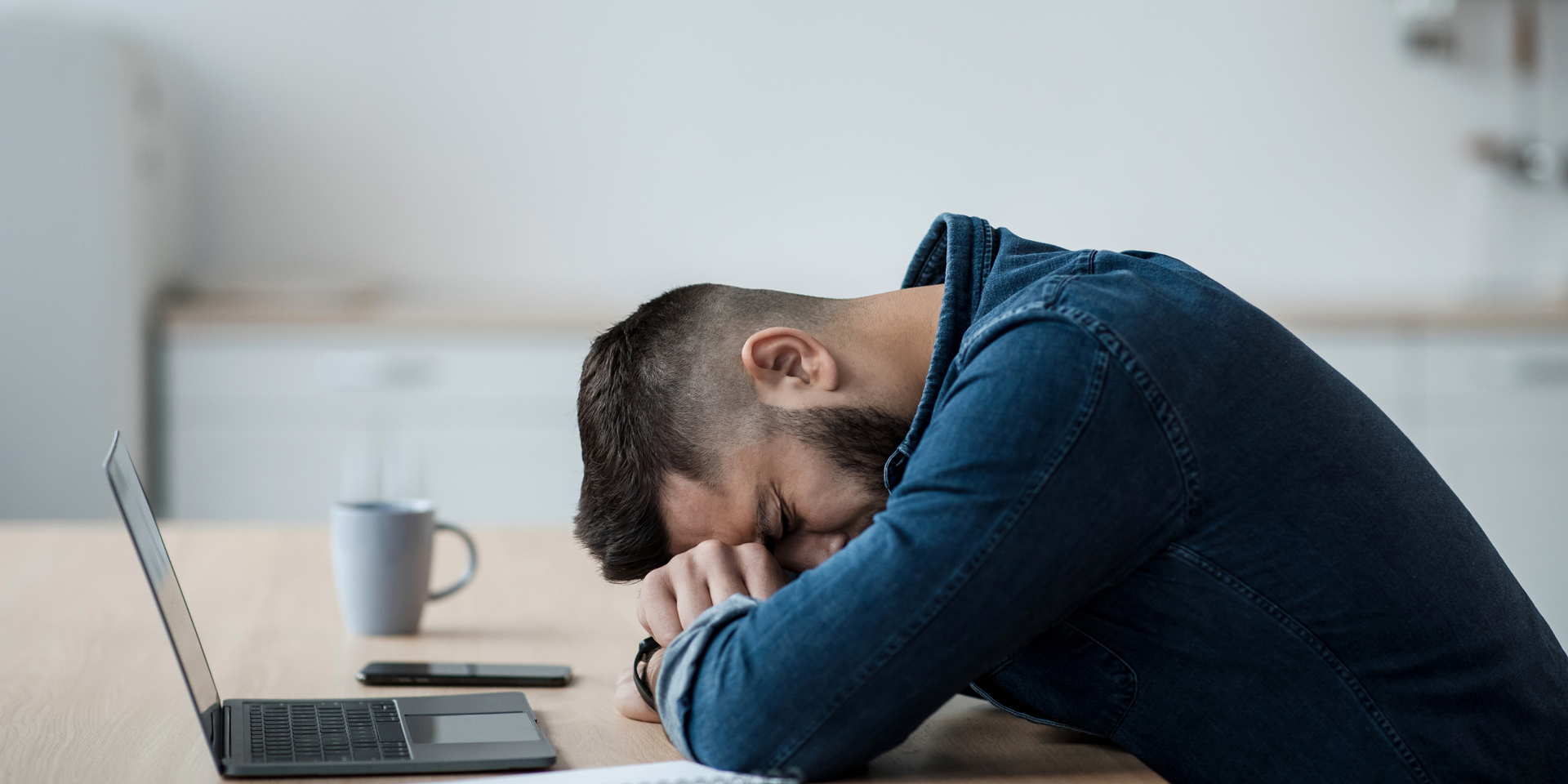 A stressed worker with his head down on the table 