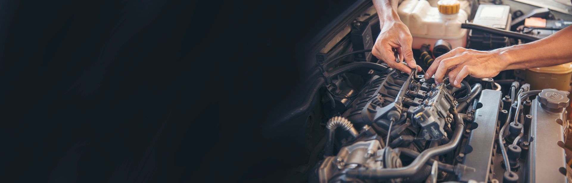 Person in workshop wipes hands with a rag. Workshop tools in the background.