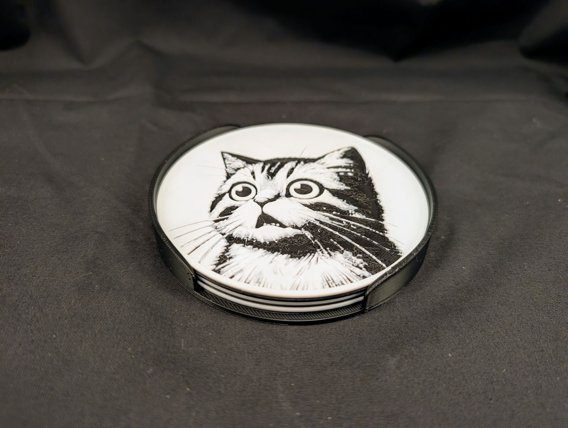 A top view of a set of four cat coasters in a holder.