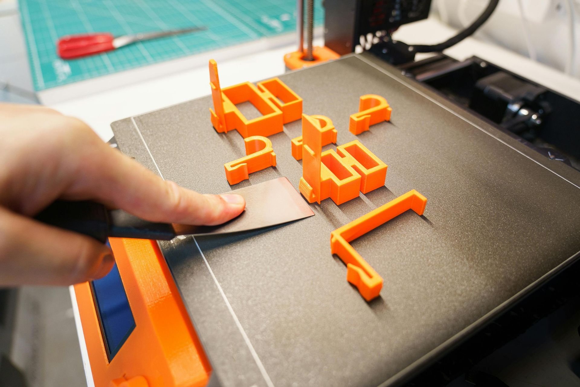 3D print shop text on an image of a 3D printer plate with 3D printed shapes.