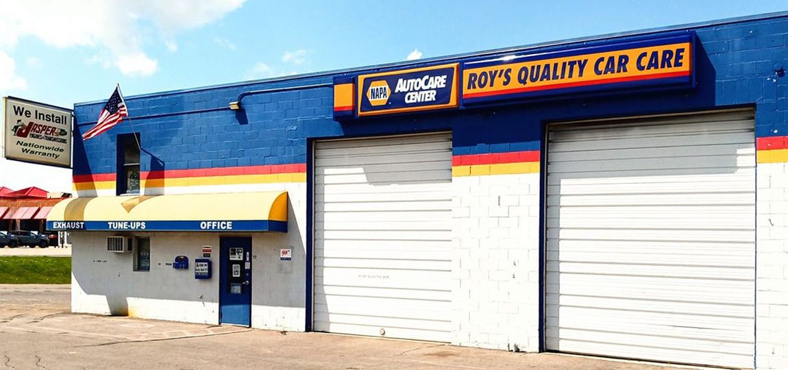 A blue and white building with a sign that says ron 's quality car care