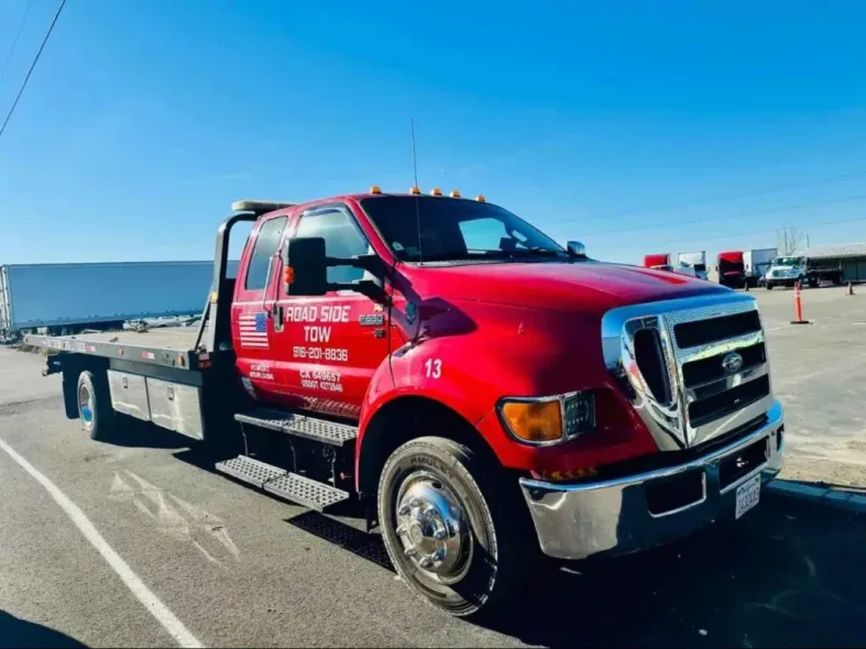 A red tow truck is parked in a parking lot.