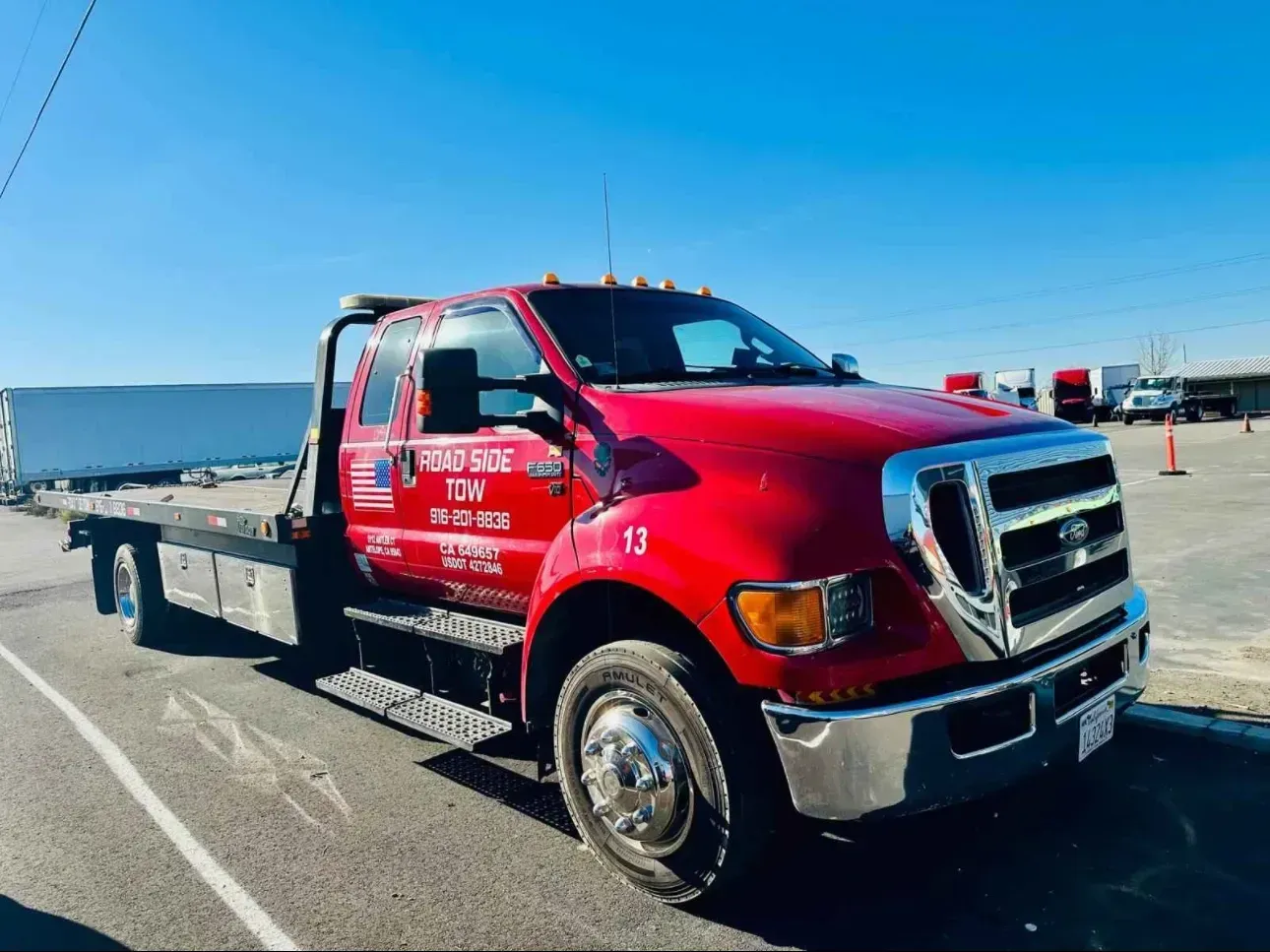A red tow truck is parked in a parking lot.