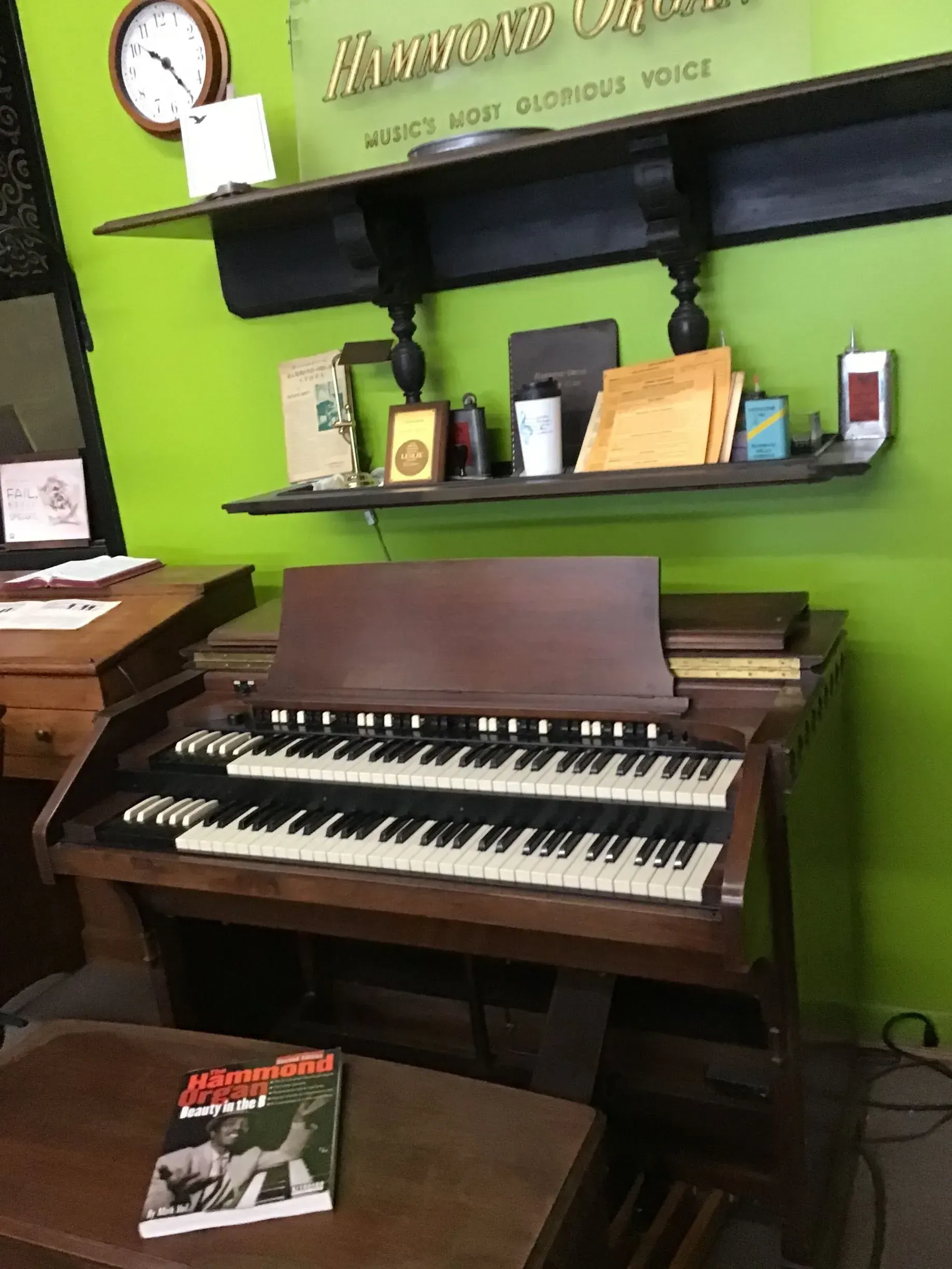 An organ is sitting in front of a green wall