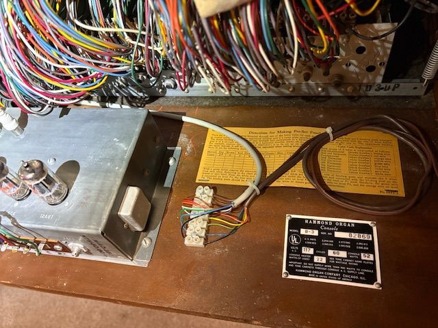 Close-up of vintage electronic components with wiring.  Includes labels, vacuum tubes, and color-coded wires.