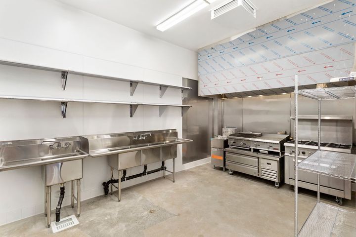 A kitchen with stainless steel appliances and sinks.