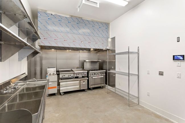 A large kitchen with stainless steel appliances and a sink.