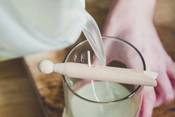 a person is pouring liquid into a glass with a wooden spoon. Hfoster ingredients