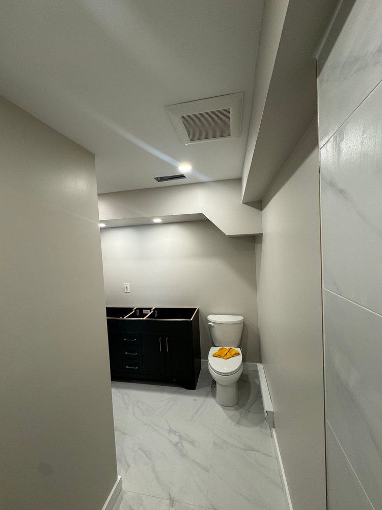 A bathroom with a toilet , sink and vanity.