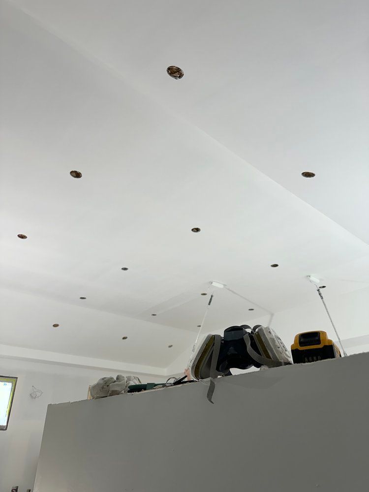 A person is working on a ceiling in a room.