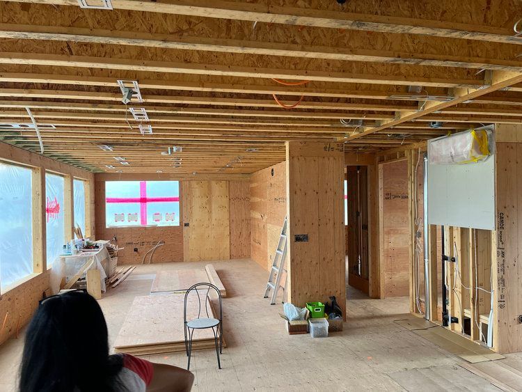 A woman is sitting in a chair in a room under construction.