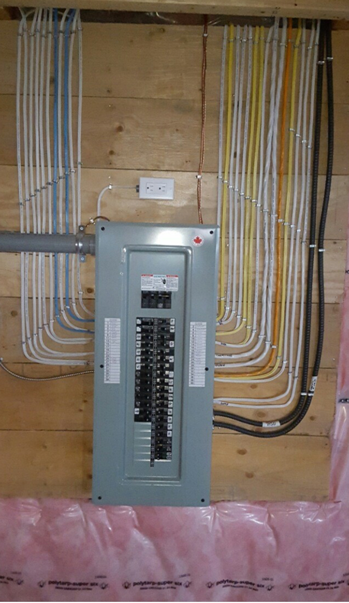 A electrical box is hanging on a wooden wall.