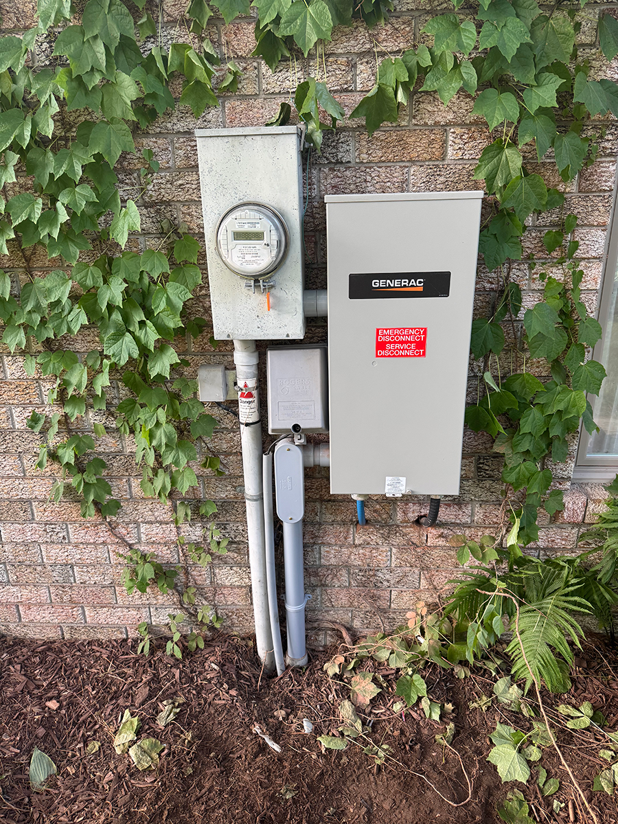 A electrical box is attached to a brick wall.