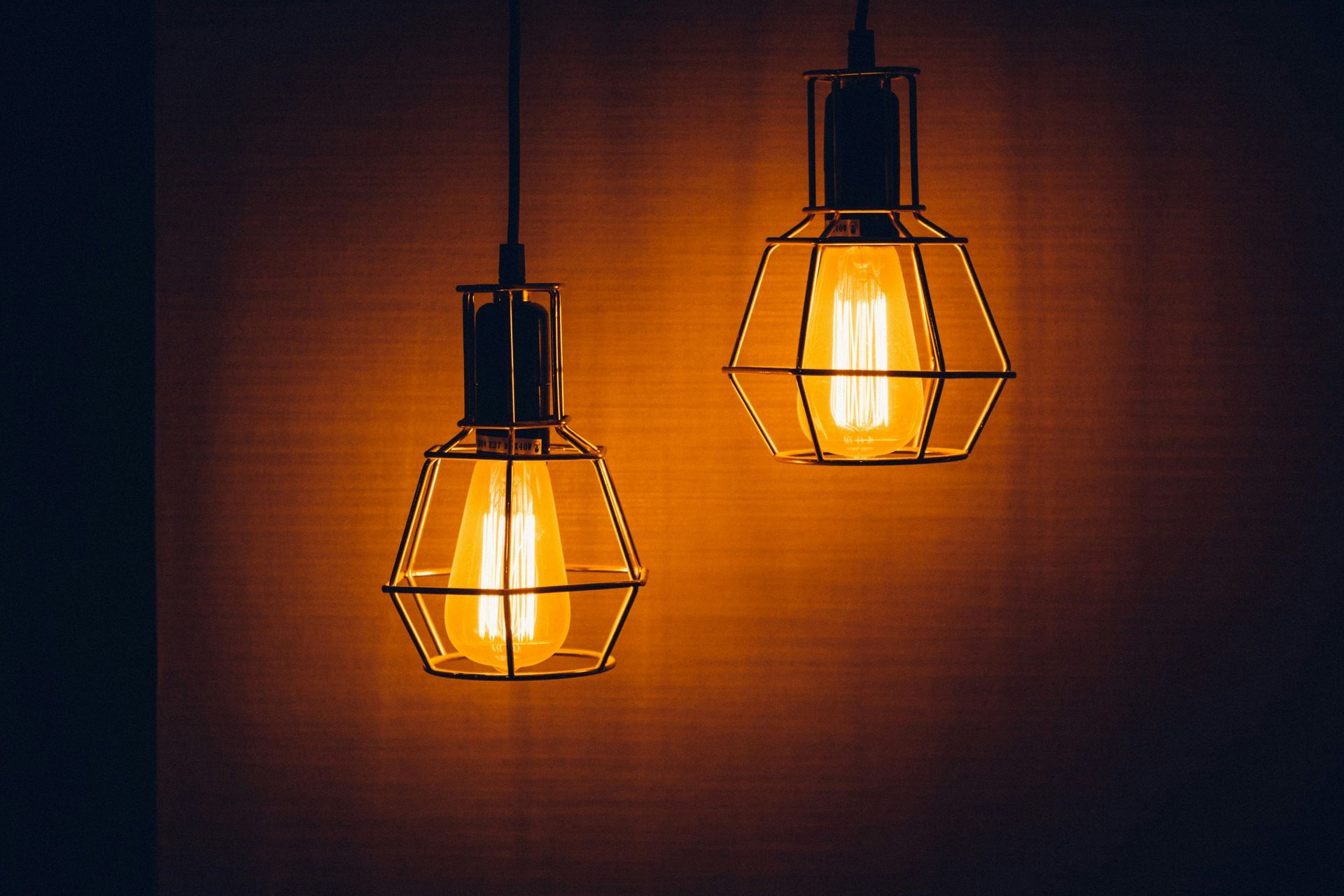 Two light bulbs are hanging from the ceiling in a dark room.