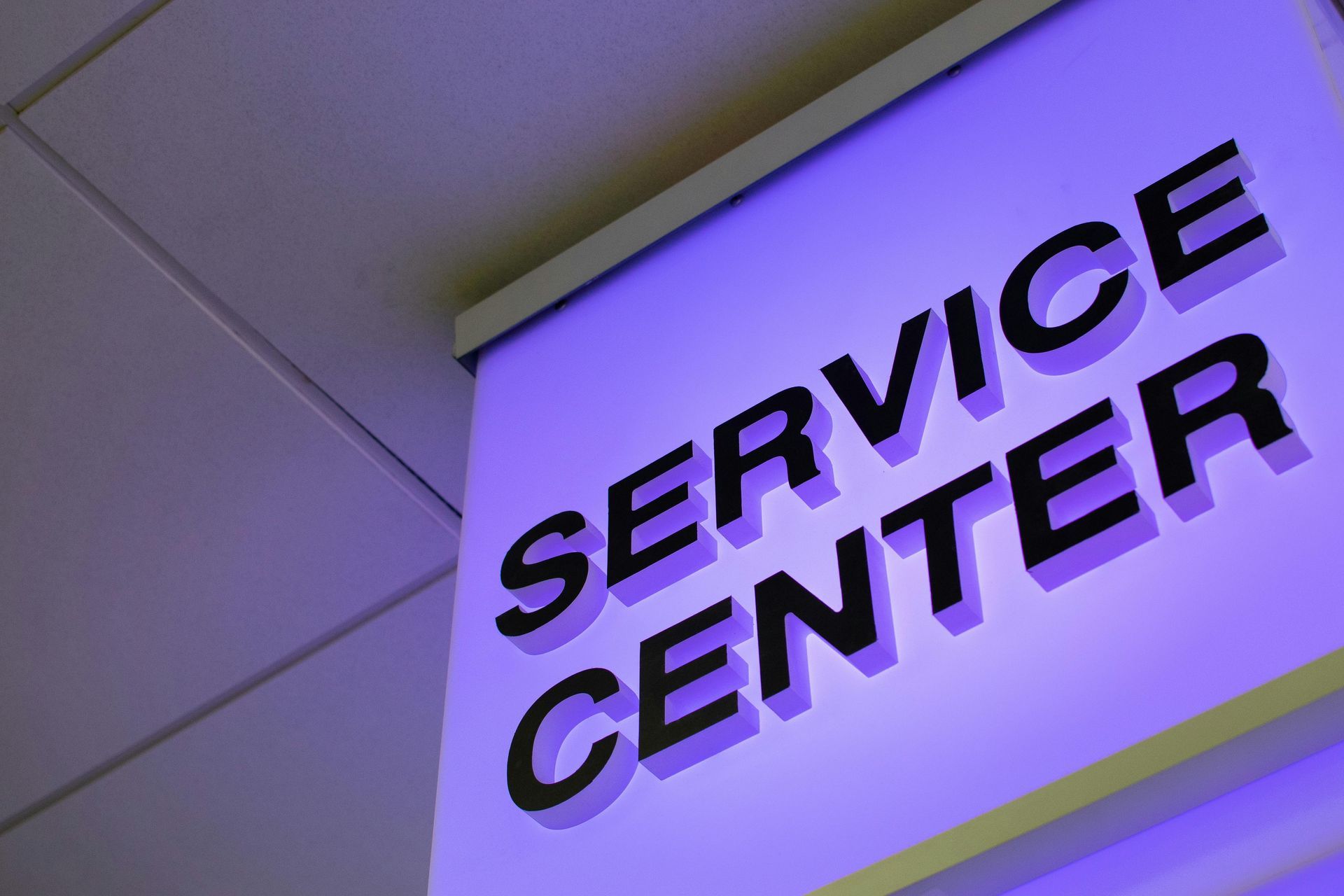 A purple service center sign hangs from the ceiling