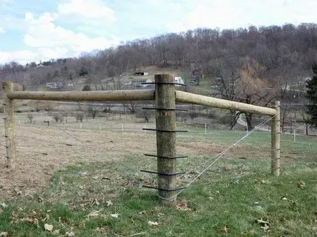 A wooden fence is sitting in the middle of a grassy field.