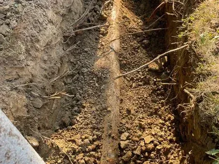 A pipe is being installed in a hole in the ground.