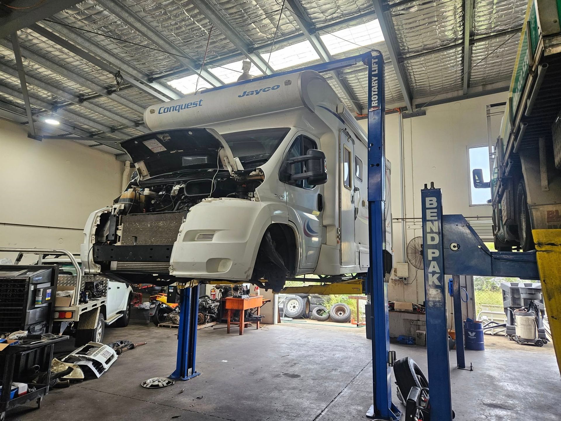 A Motorhome is on a Lift in a Repair Shop With Its Hood Open — R&B Automotive PTY LTD In Urangan, QLD