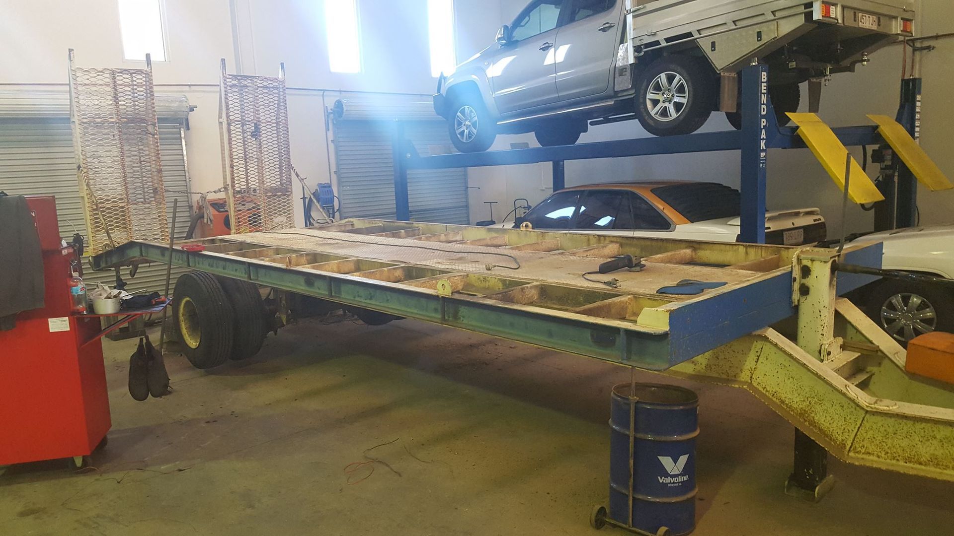 A Large Trailer in a Garage, With a Car on a Lift in the Background — R&B Automotive PTY LTD In Urangan, QLD