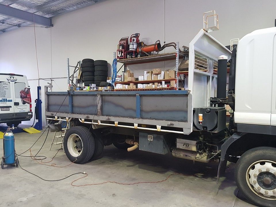 Truck Bed Under Construction Inside a Workshop, With Tires, Shelves, and Welding Equipment — R&B Automotive PTY LTD In Urangan, QLD