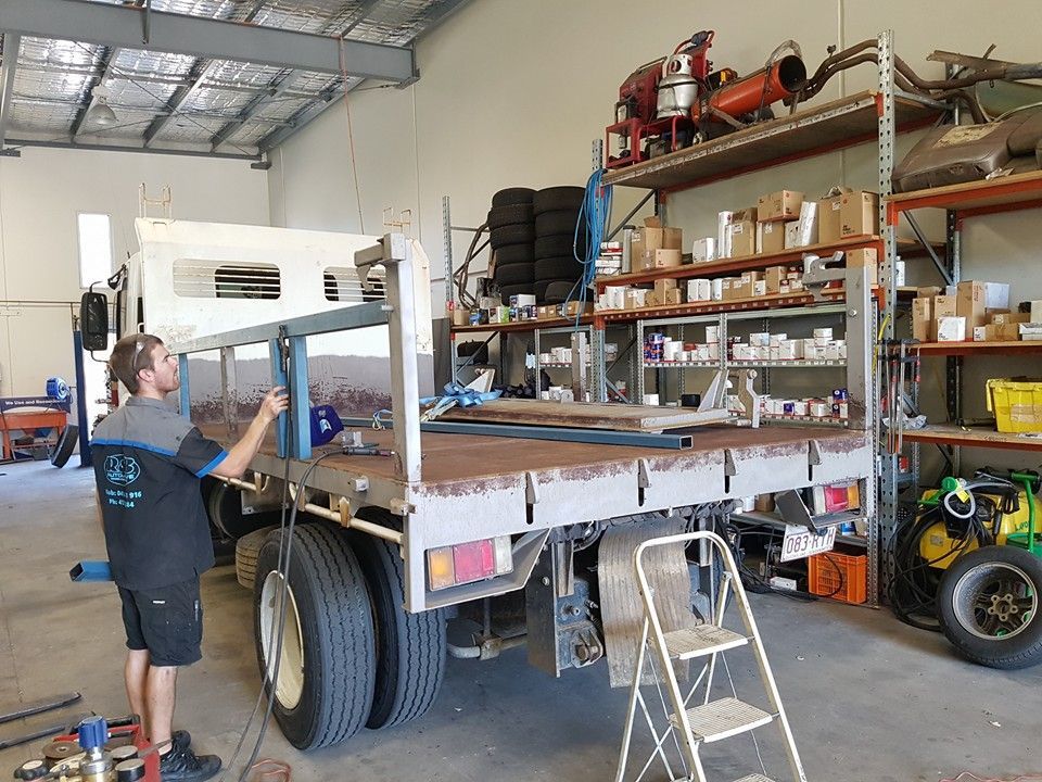 A Man Working on the Bed of a Truck Inside a Workshop — R&B Automotive PTY LTD In Toogoom, QLD