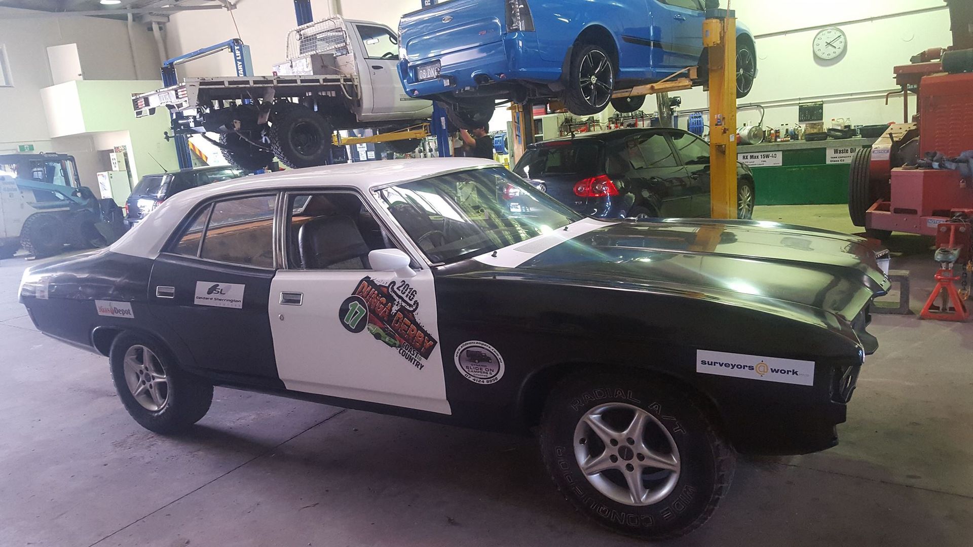 Black and White Classic Car With Racing Decals Inside a Garage — R&B Automotive PTY LTD In Maryborough, QLD