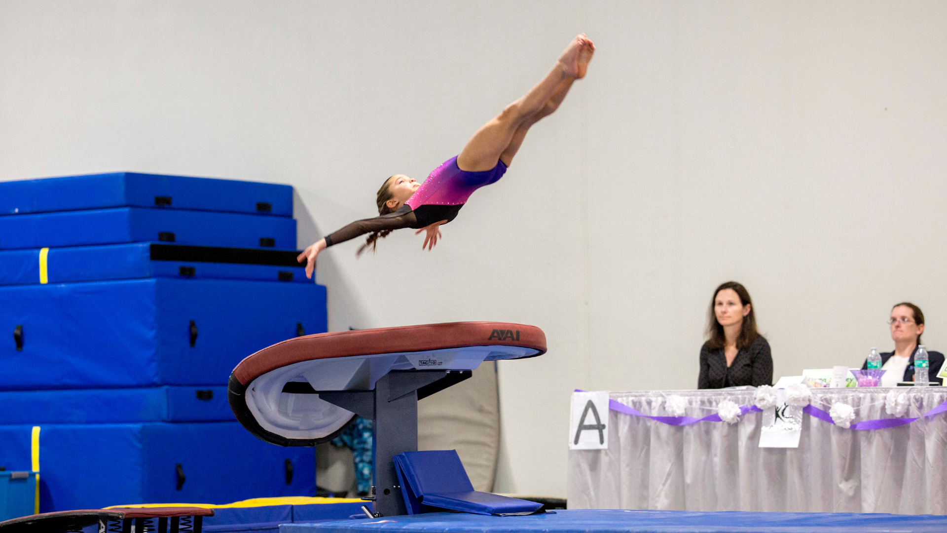 Gymnast performing a front handspring over a table