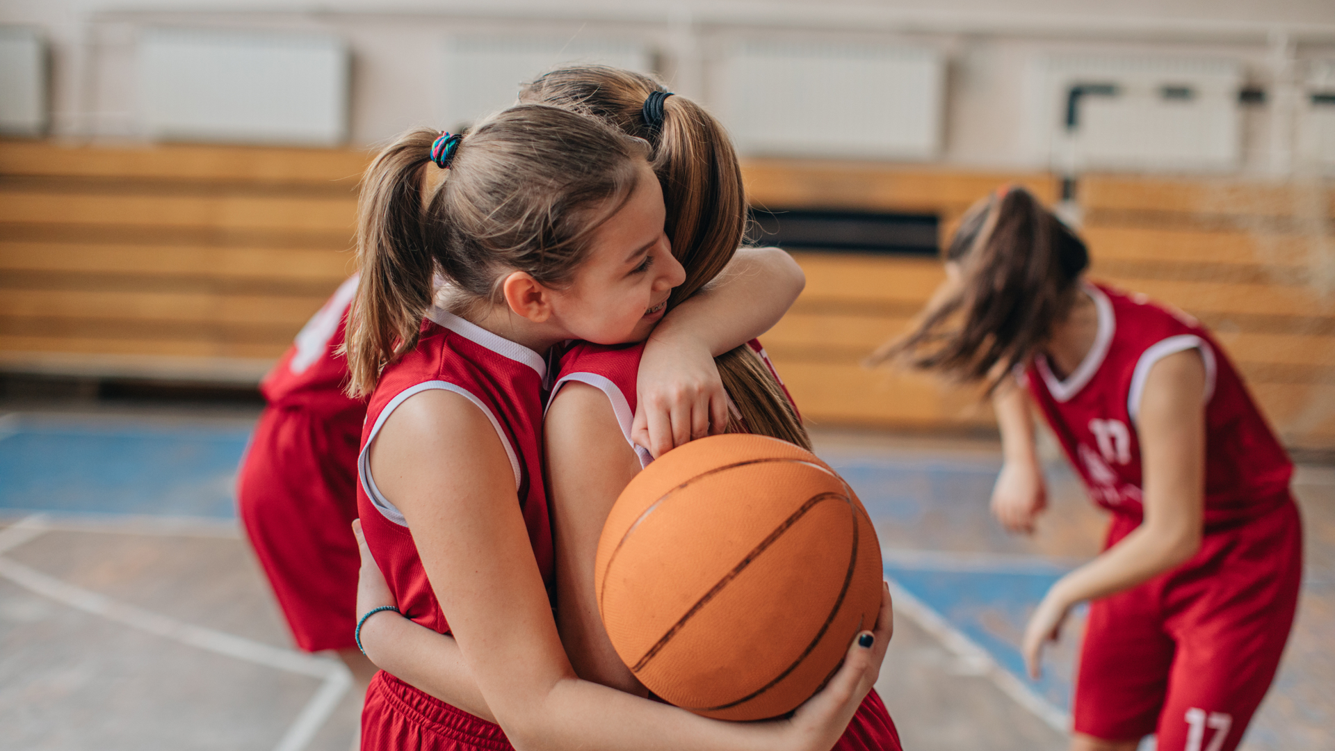 two girls displaying kindness after a youth basketball game