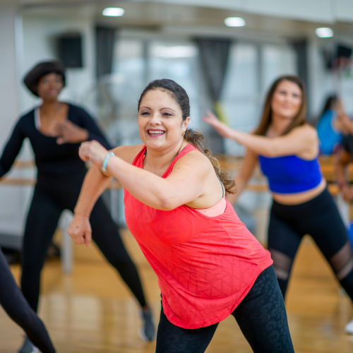 A woman in a red tank top at an adult dance class