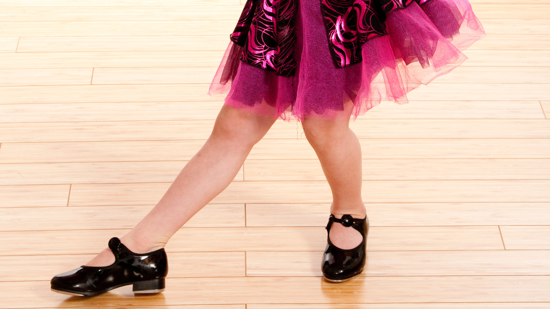 three year old in black tap shoes practicing her dance moves