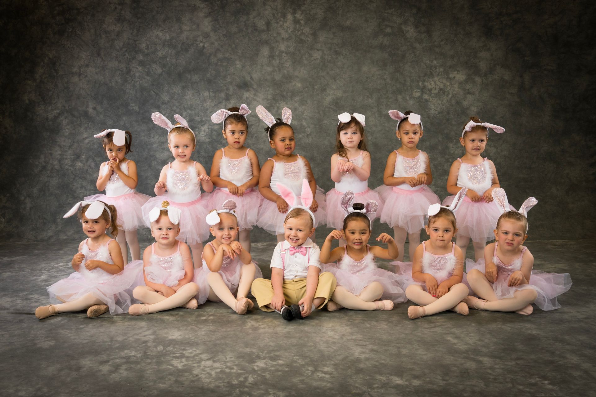 two year old girls and boys posing in bunny costumes preparing for a dance performance