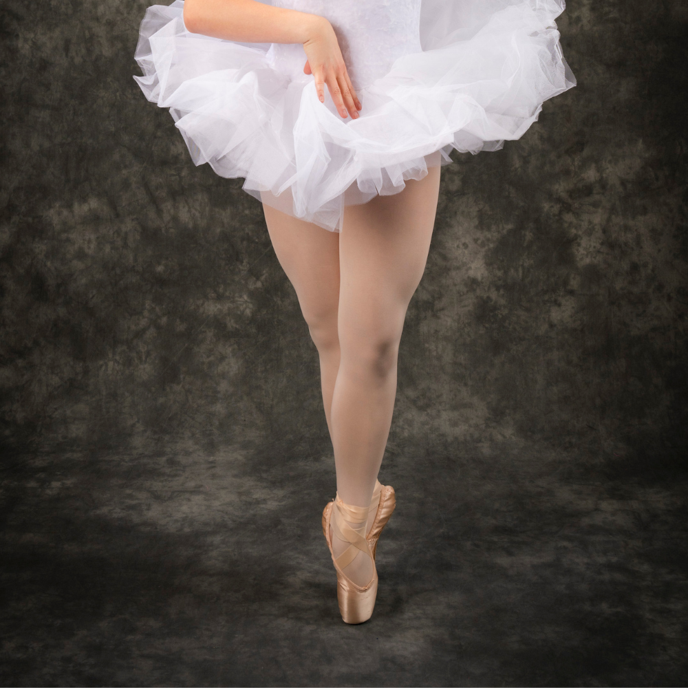 A ballerina in a white tutu and pointe shoes