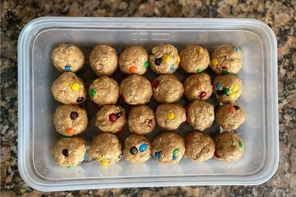 Tupperware container with rows of protein balls that include protein powder, oats, and m&ms