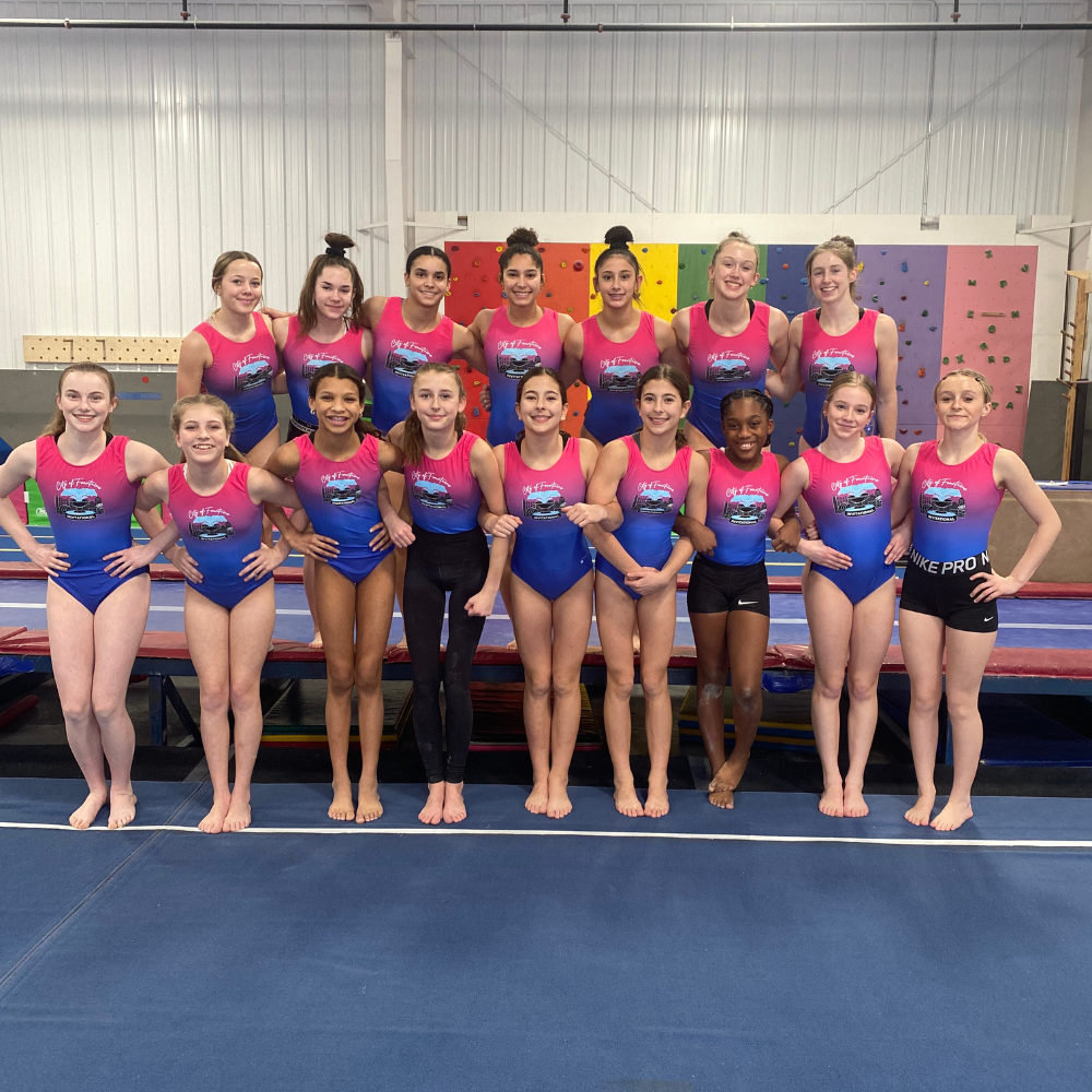 A group of female gymnasts are posing for a picture