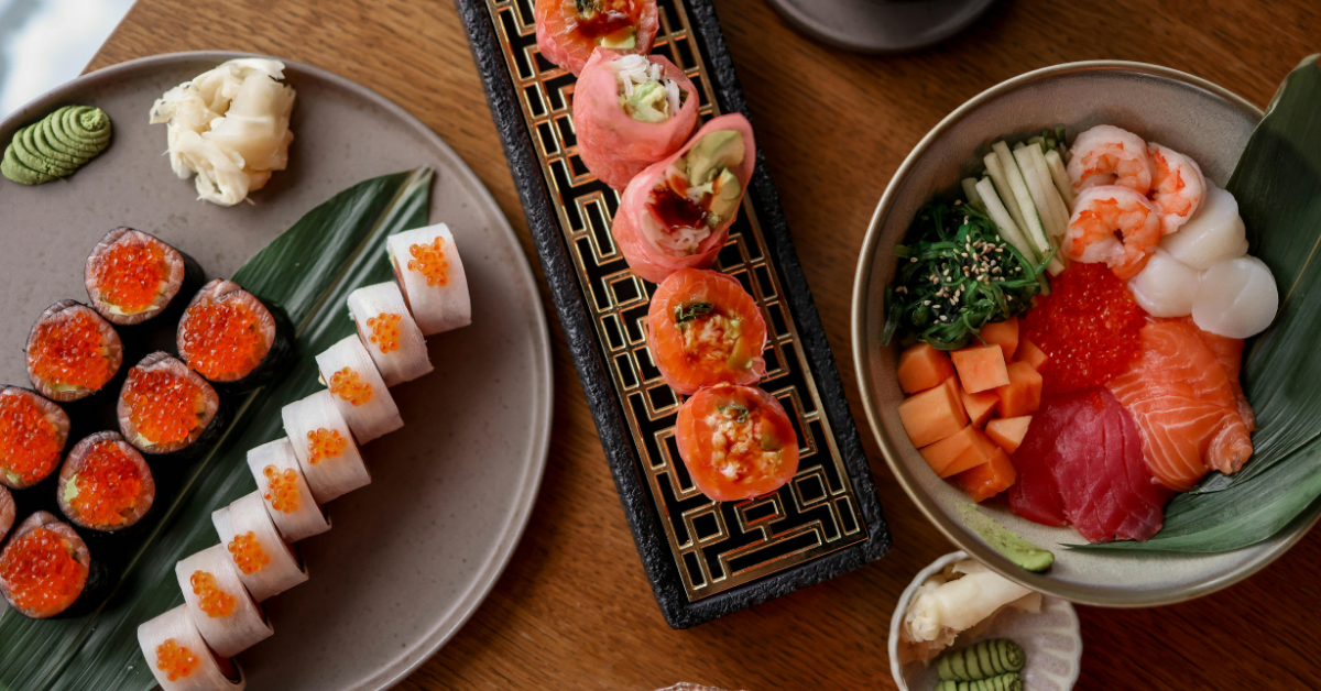 a variety of sushi and fish dishes to be shared by a family at a restaurant