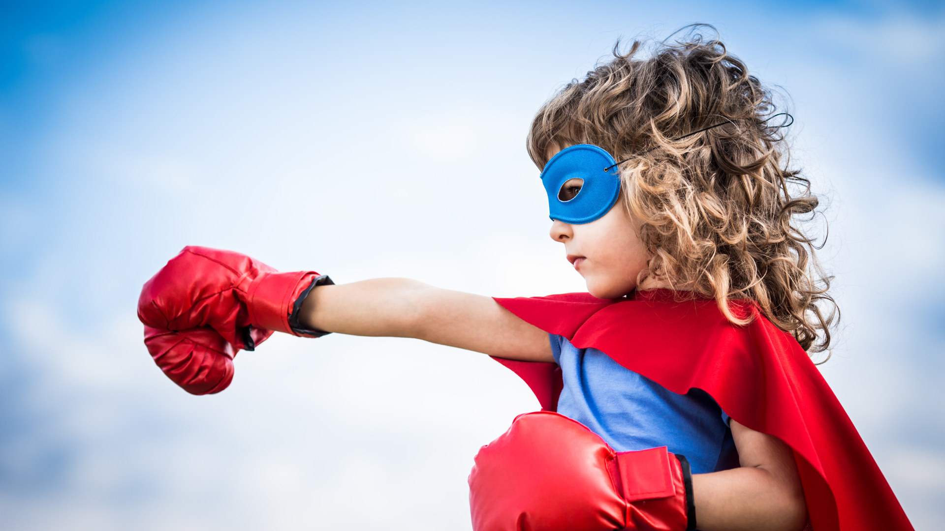a child with red gloves displaying resilience by fighting back