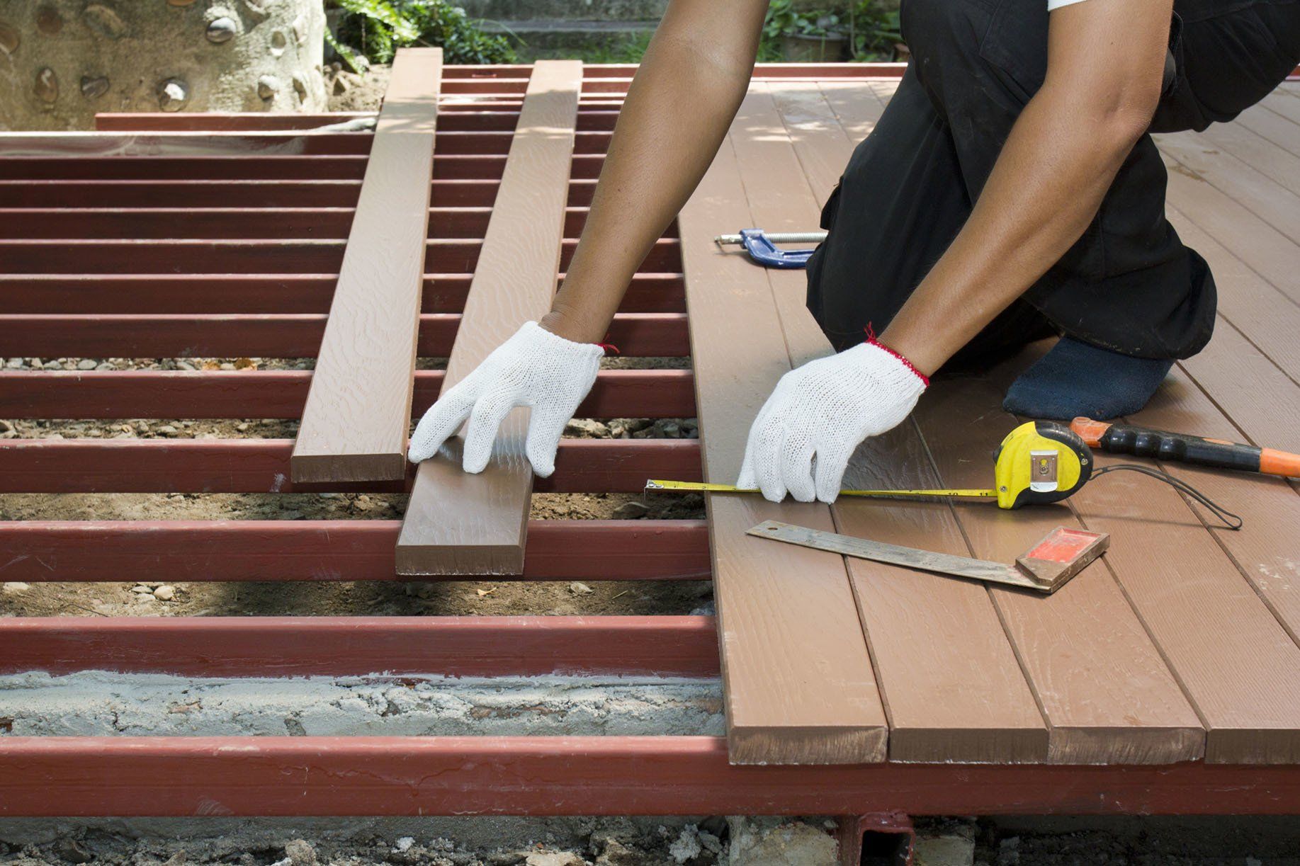 Decks — Construction Worker Installing an Outdoor Patio in Clayton, NC Decks — Construction Worker Installing an Outdoor Patio in Clayton, NC