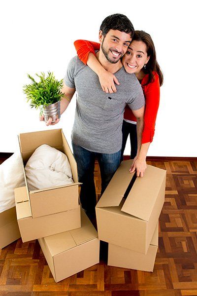 A couple moves boxes into their new home.