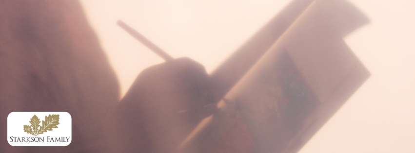 Fuzzy image of a person writing in a notebook