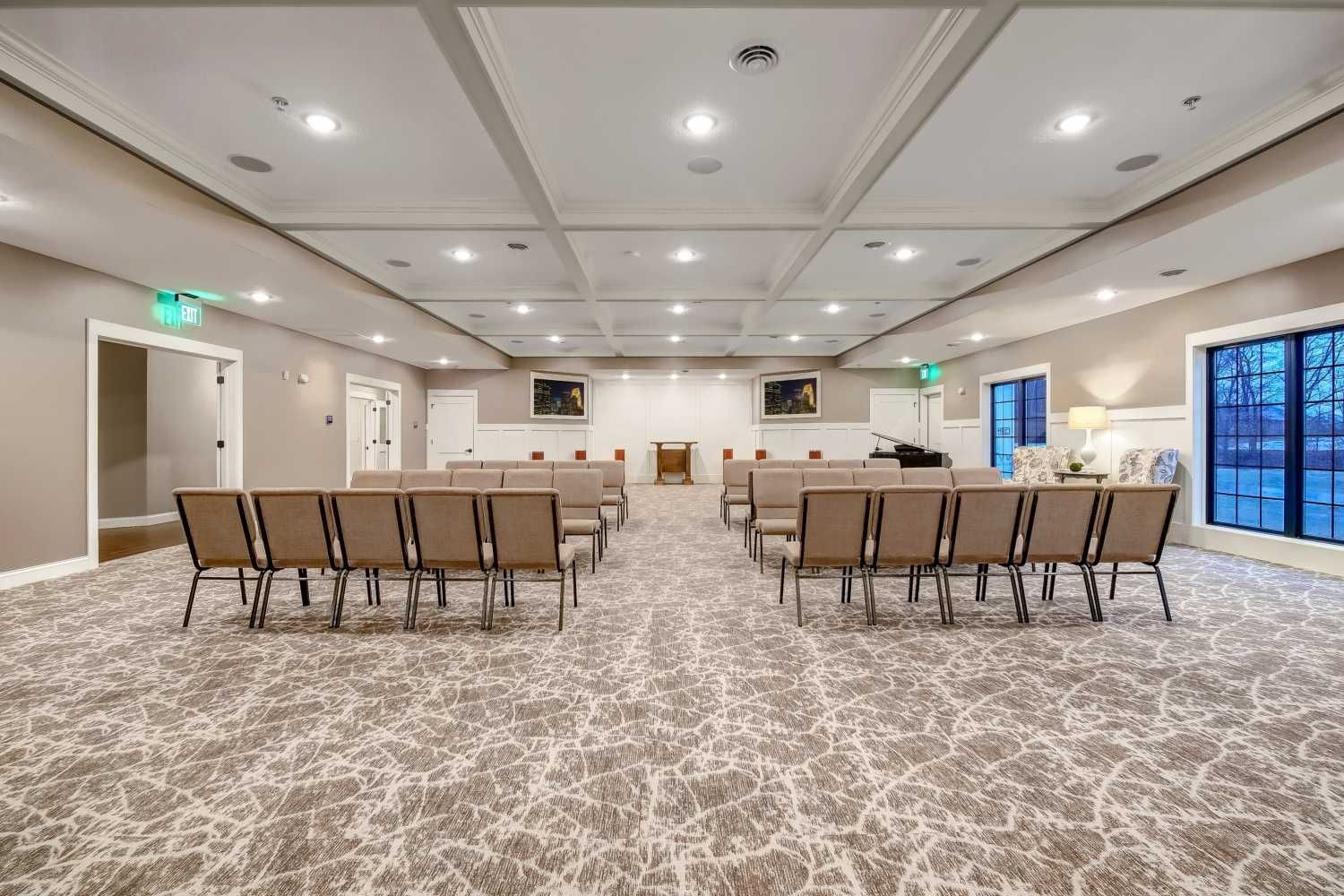 A large room with rows of chairs and a piano in it.