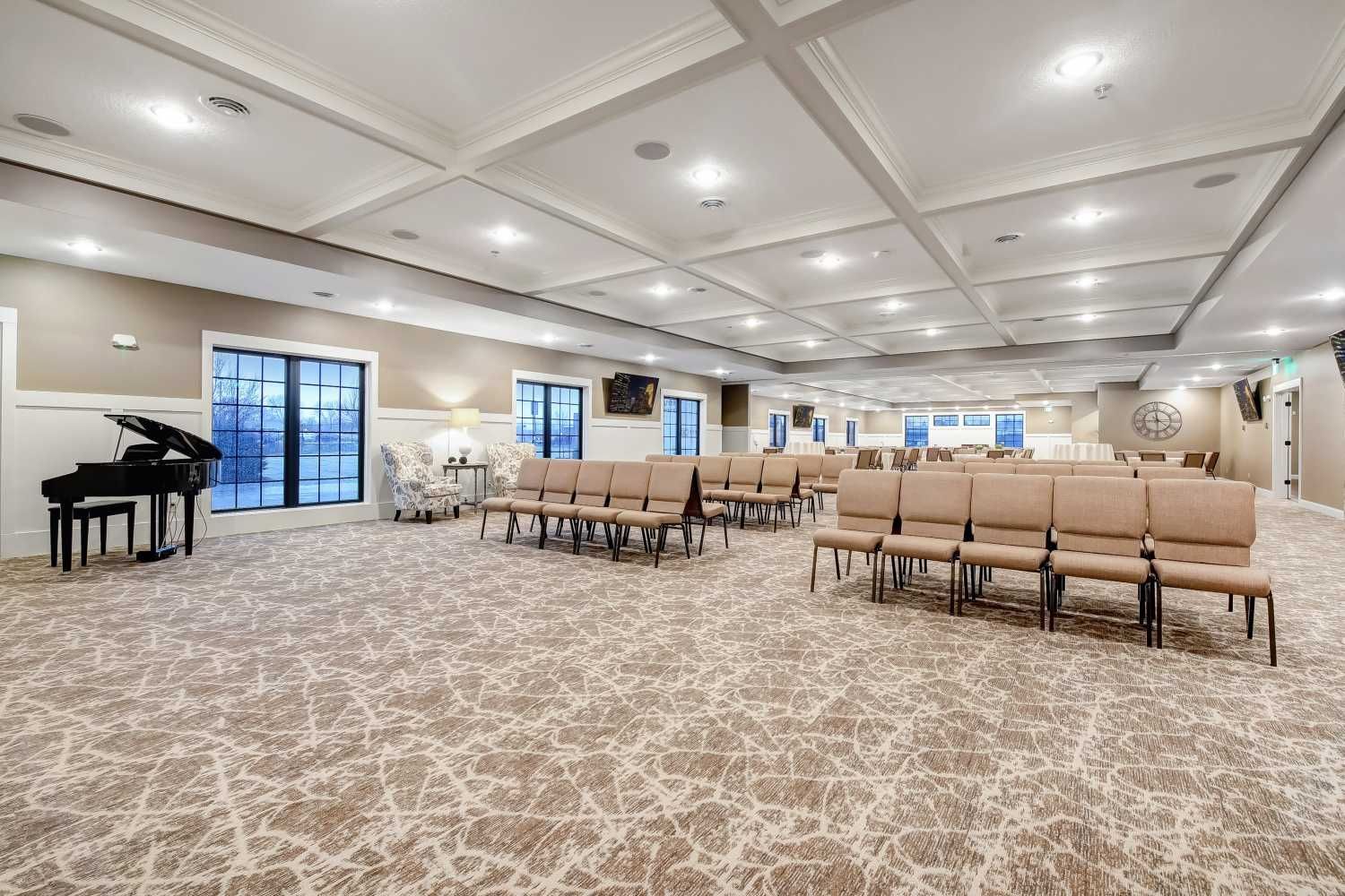 A large room with a piano and chairs in it.