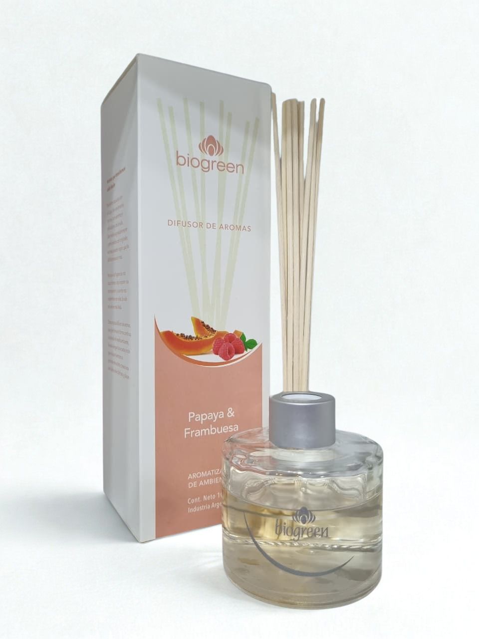 Difusor de varillas transparente con tapa gris junto a una caja de color melocotón